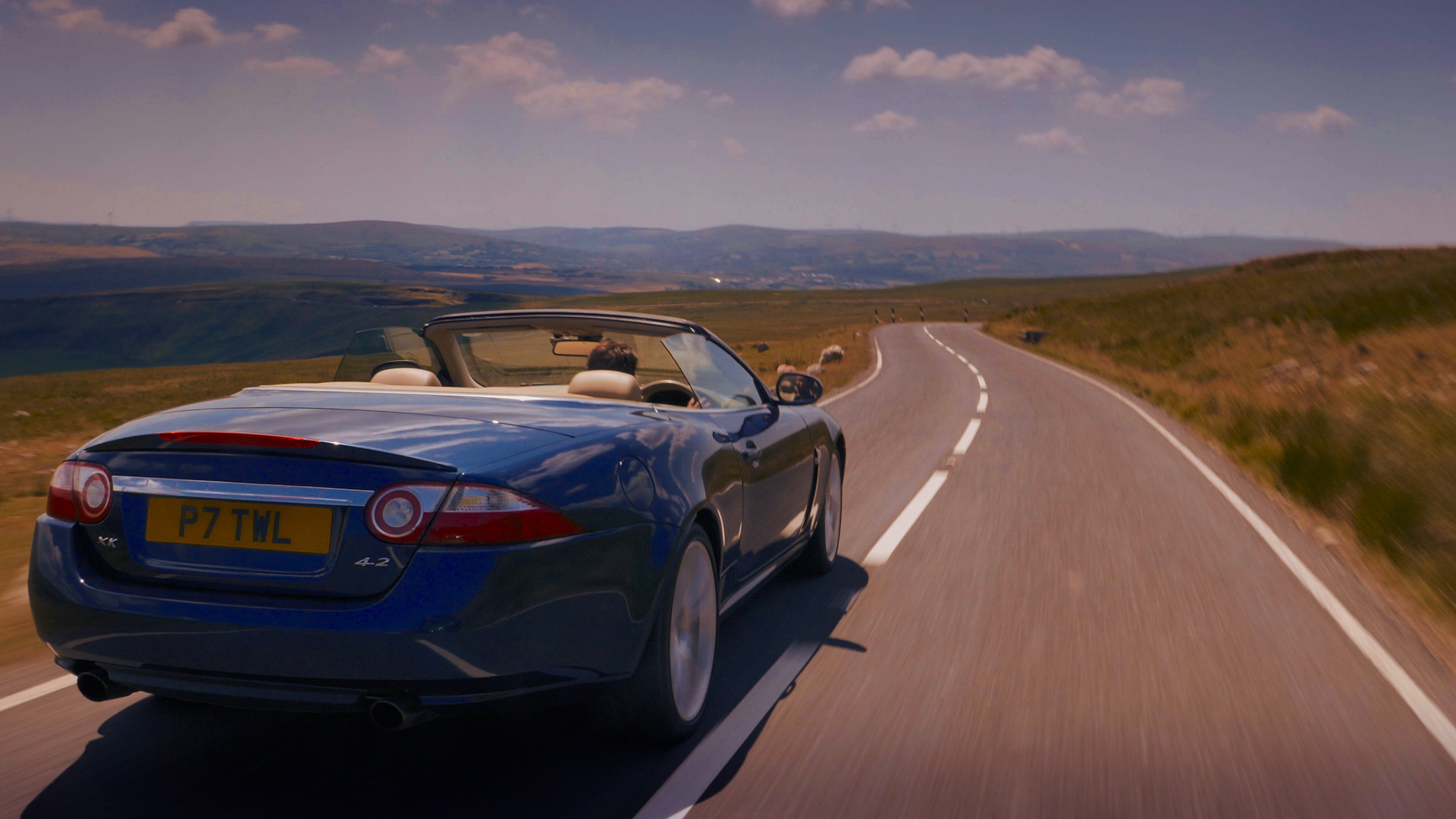 end of an era, last of the v8's, rear view of jaguar sports car on country road